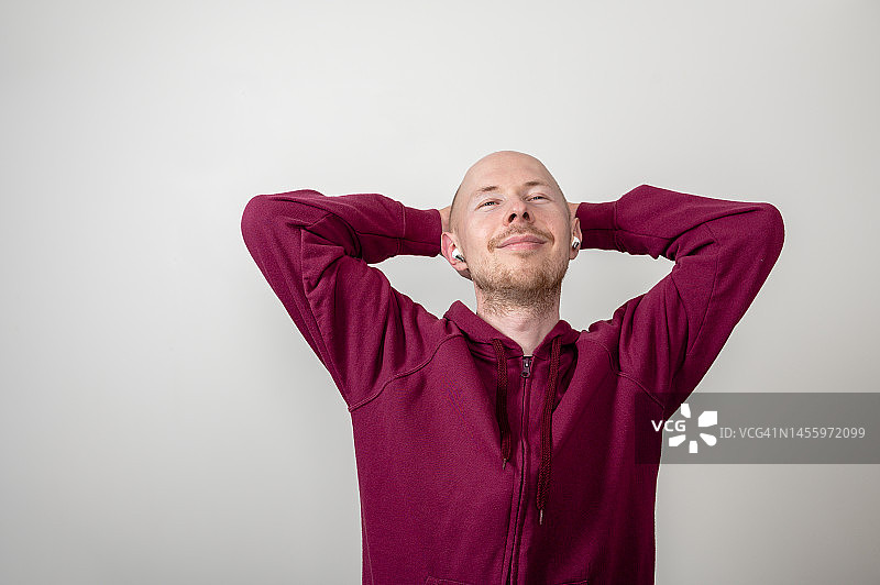 穿连帽衫的光头男人伸展微笑图片素材