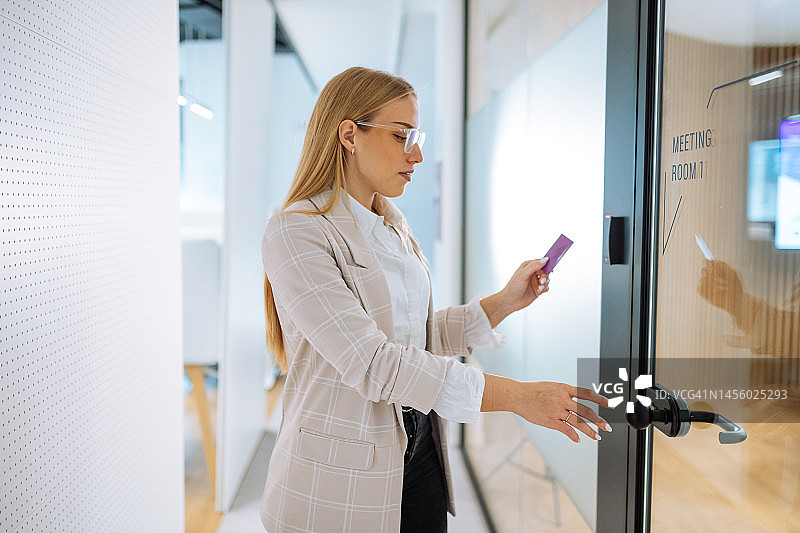办公室里的女商人用非接触式卡钥匙打开会议室的门图片素材