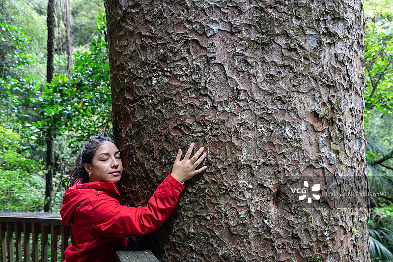 森林里身穿红色夹克的年轻女人图片素材