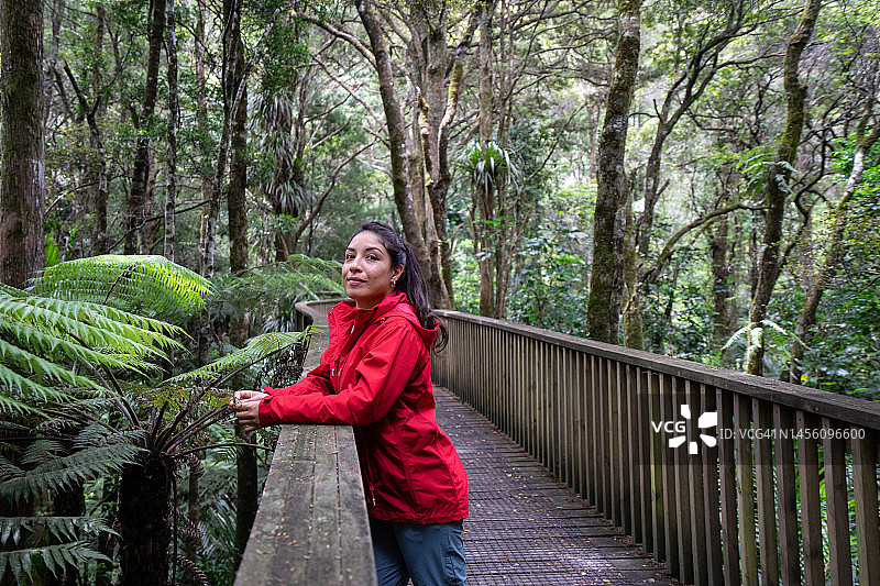 森林里身穿红色夹克的年轻女人图片素材