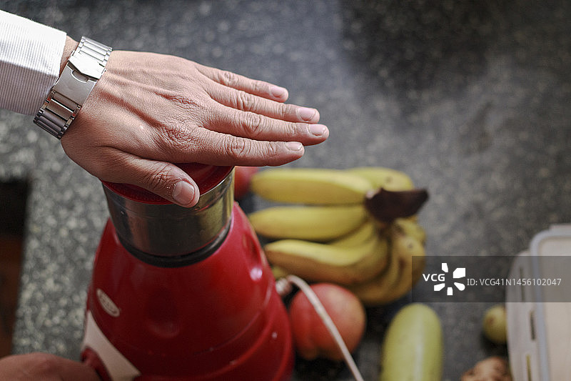 在厨房使用搅拌研磨机的商务男士图片素材
