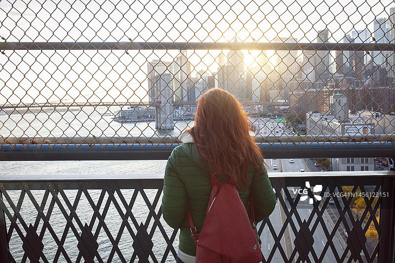 女子在纽约曼哈顿大桥欣赏曼哈顿日落图片素材
