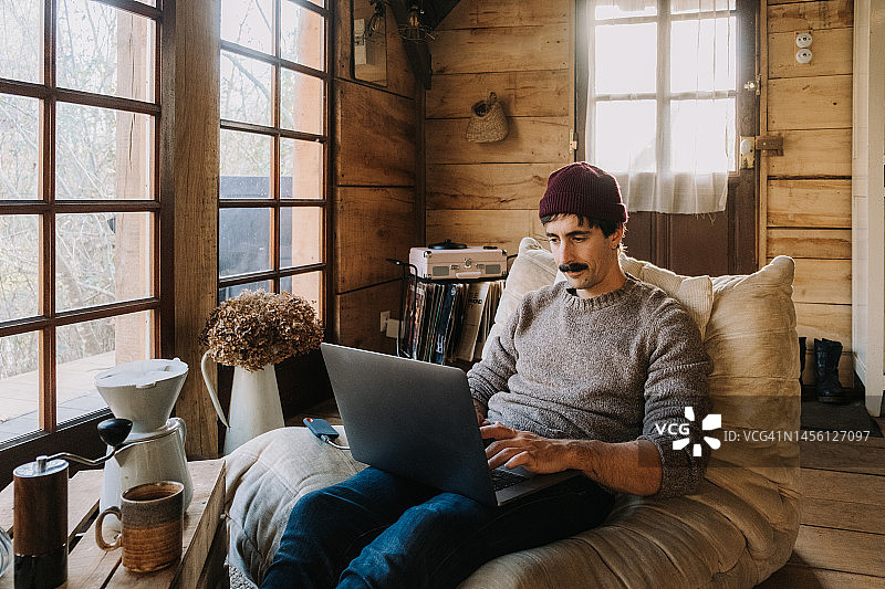 成年男子在木屋窗口远程办公图片素材