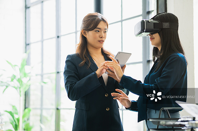 在办公室戴VR眼镜的兴奋的亚洲女测试员图片素材