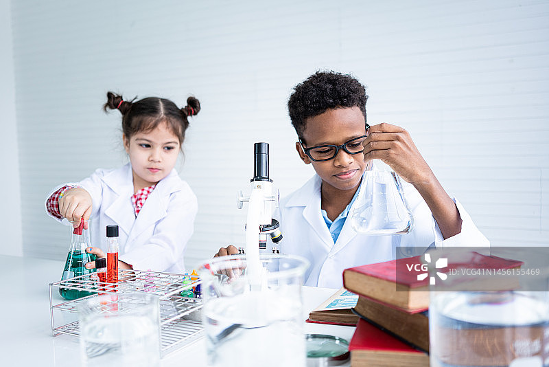 童年：学生和朋友在教室实验室里学习科学图片素材