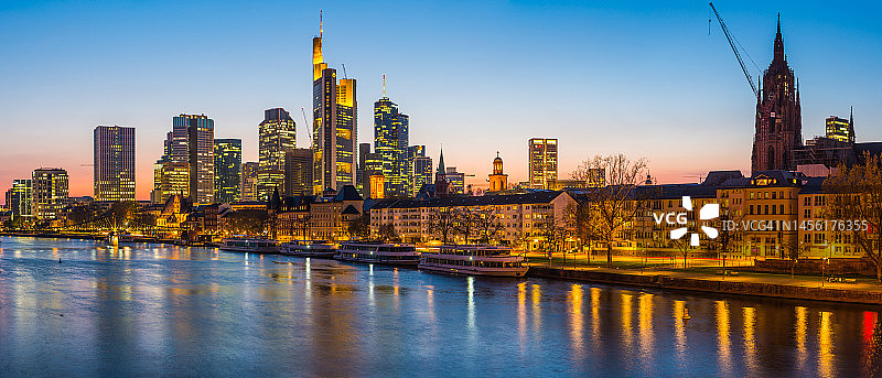 法兰克福摩天大楼在日落时分于美因河上闪耀，德国全景图片素材