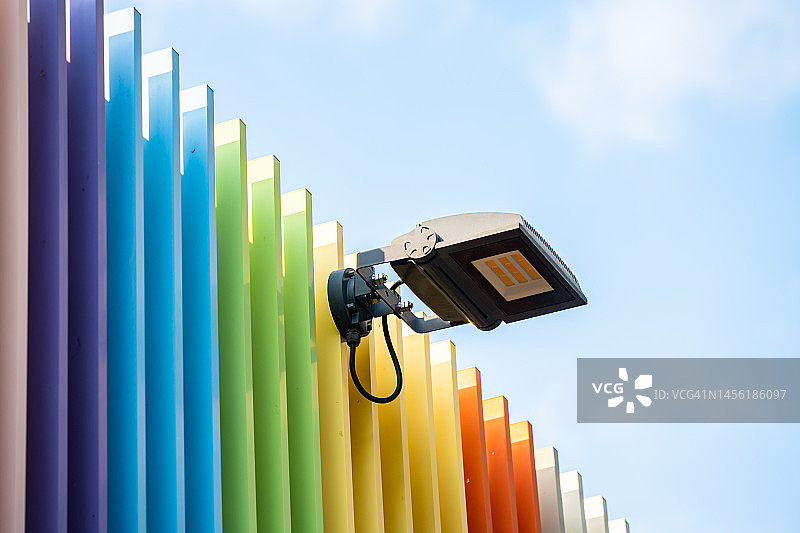 彩色彩虹栅栏和紫色瓷砖路上的光芒，以天空为背景图片素材