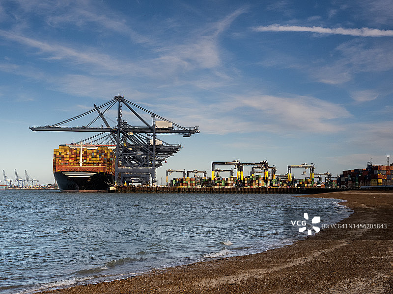 从海滩看到的费利克斯托集装箱港口起重机和船只图片素材