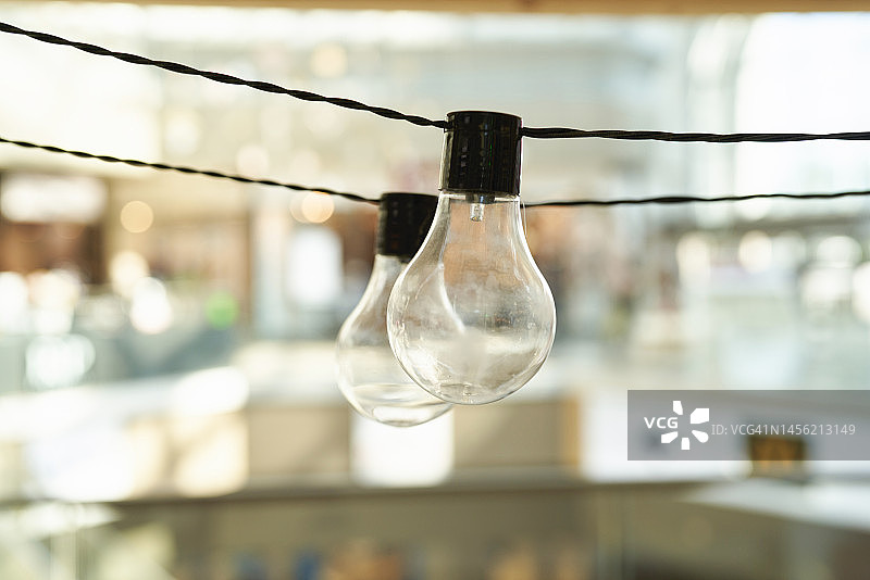 商场中悬挂的两盏未点亮的灯泡图片素材