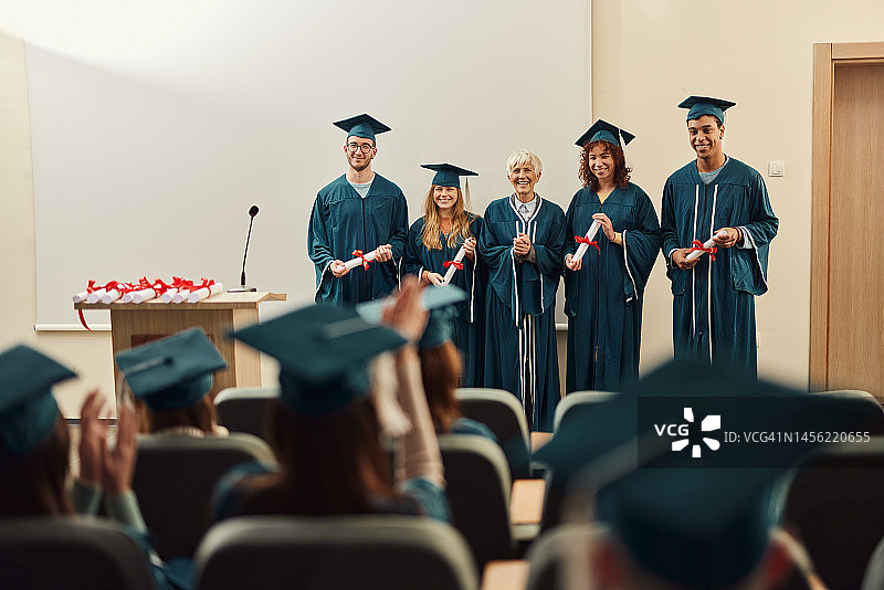 自豪的资深教授和她在毕业典礼上获奖的学生图片素材