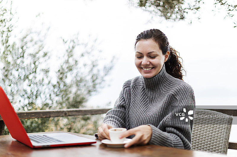 女人在乡间别墅远程办公，手捧一杯咖啡图片素材