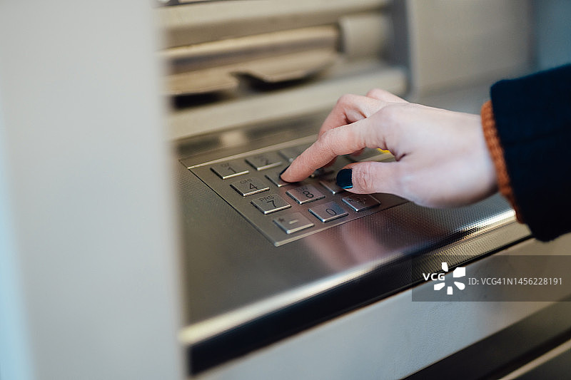女性在自动柜员机（ATM）键盘上输入密码特写图片素材