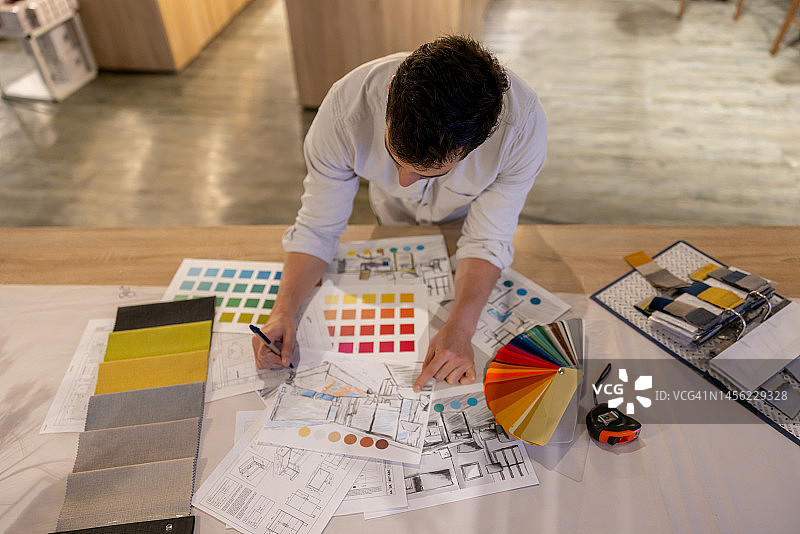 室内设计师在家具店工作时绘制设计图图片素材