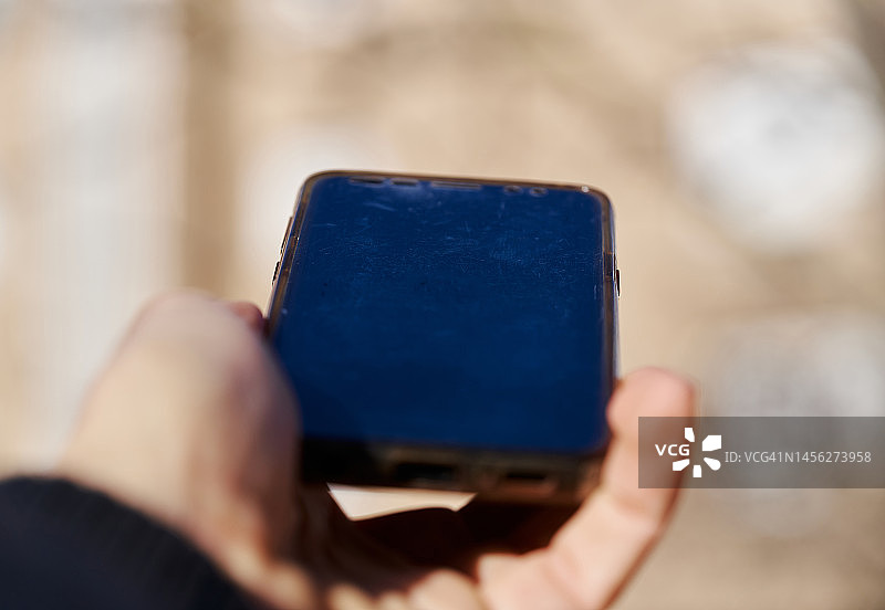 手持屏幕损坏的关机手机图片素材