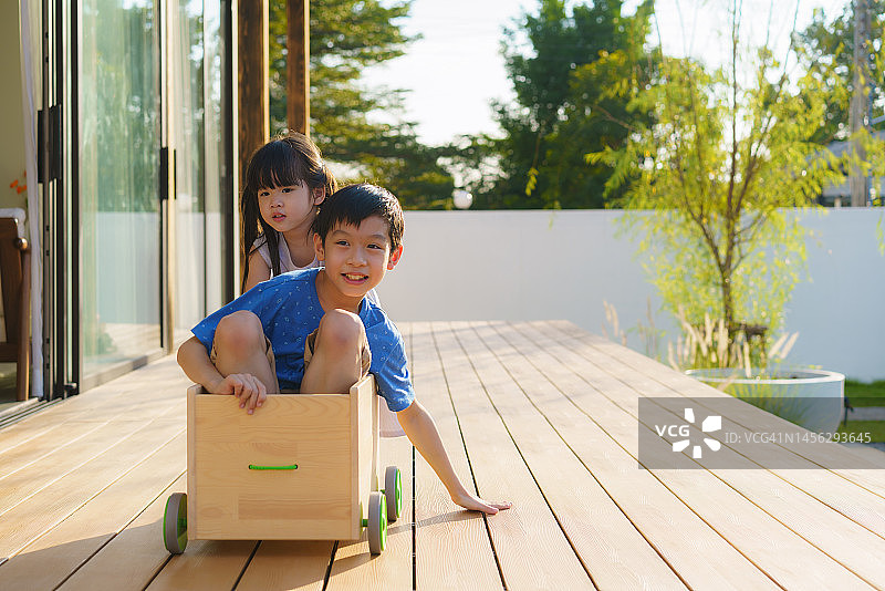亚洲兄妹在阳台上快乐地玩耍，兄妹间的亲情概念图片素材