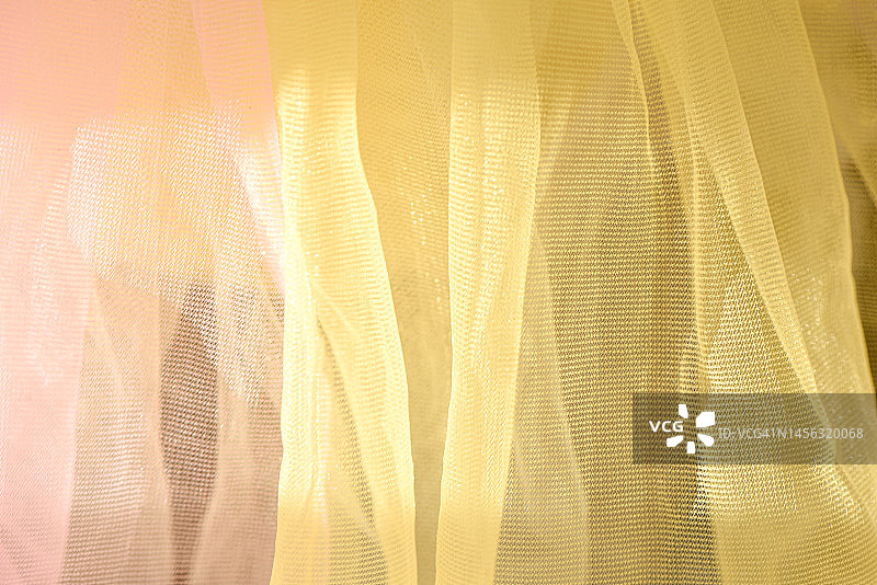 阳光下的粉色和黄色薄纱面料特写图片素材