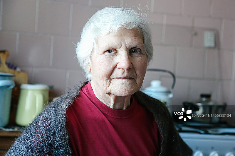 在家看着镜头的年长单身女人肖像图片素材