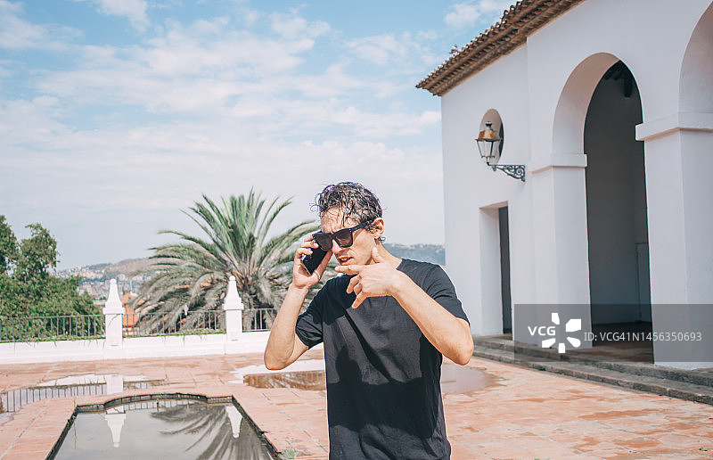 戴太阳镜的年轻男人在夏天打电话图片素材