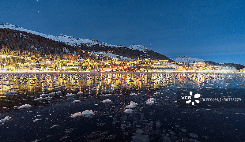 圣莫里茨的阿尔卑斯山村庄与黄昏时分的冰冻湖面图片素材