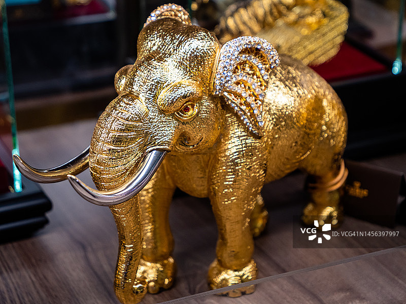 泰国曼谷奢侈品店展示的金色钻石大象雕像，常作为礼物和幸运符图片素材