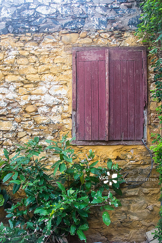黄色石墙上的红色窗户图片素材