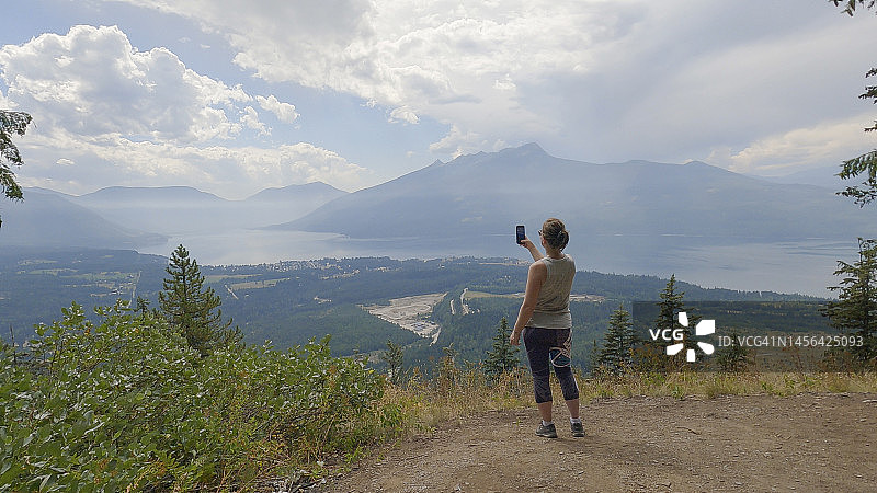 女人在森林瞭望台拍照图片素材