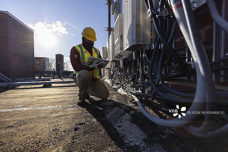 维修人员在屋顶检查电信设备图片素材