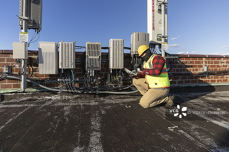 维修人员在屋顶检查电信设备图片素材