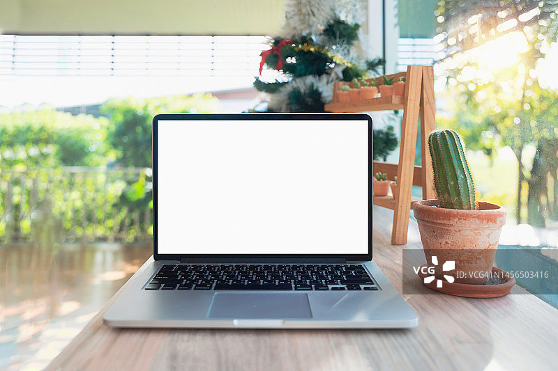 咖啡馆背景中桌子上的笔记本电脑空白屏幕图片素材