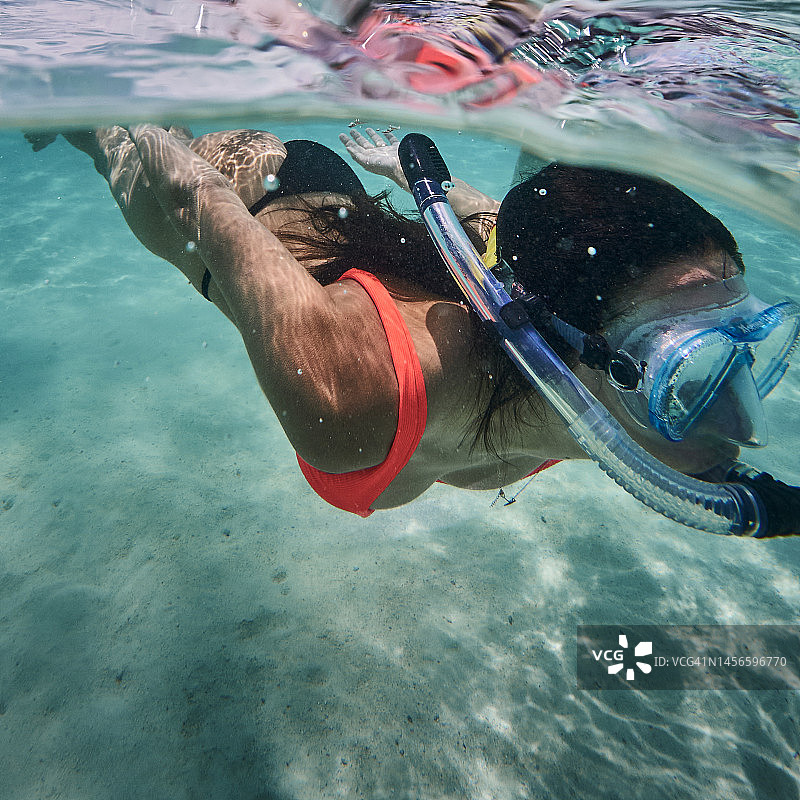 水下视角：女性使用水下相机浮潜图片素材