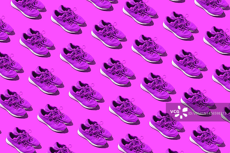 紫色背景上使用过的紫色运动鞋的图案。运动概念、妇女节、、马拉松、赛跑、健康生活、训练与舒适。图片素材