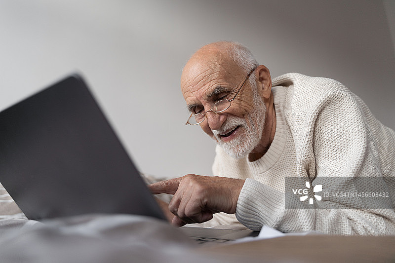 在家用笔记本电脑学习或工作的老人图片素材
