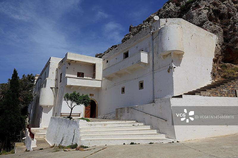 克里特岛莫尼法内罗梅尼斯前防御修道院，阿吉奥斯尼古拉斯沿海公路附近山上的白色修道院图片素材