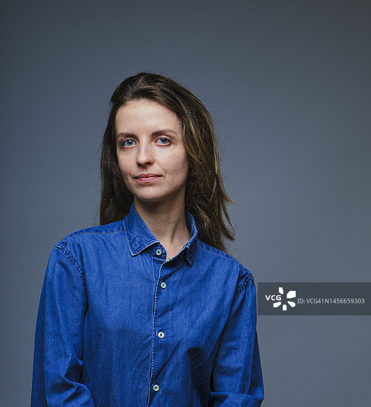 穿着蓝色牛仔衬衫的严肃女人图片素材