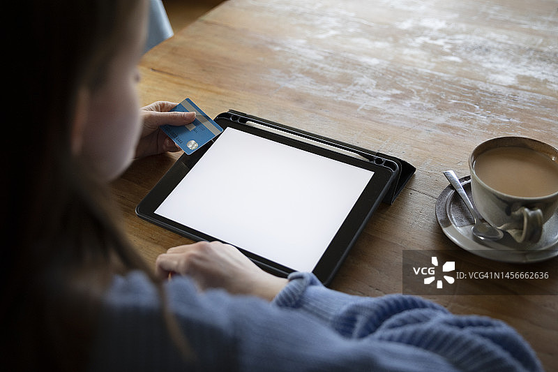 年轻人用信用卡在平板电脑上进行网购图片素材