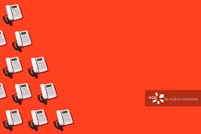 红色背景上的白色复古电话图案，体现旧时代通讯和客服概念图片素材