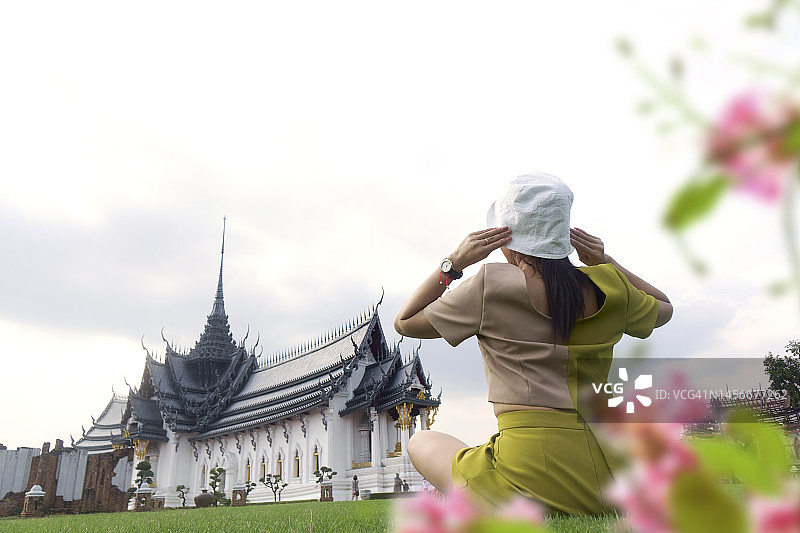 坐在佛寺草地上的亚洲女性背影图片素材