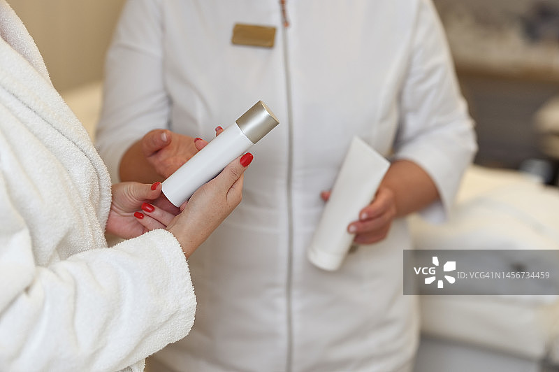 美容院里，女人向顾客推荐化妆品图片素材