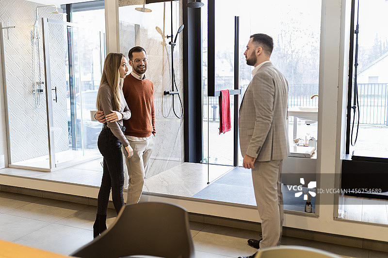 销售员在浴室用品店帮助一对年轻夫妇图片素材