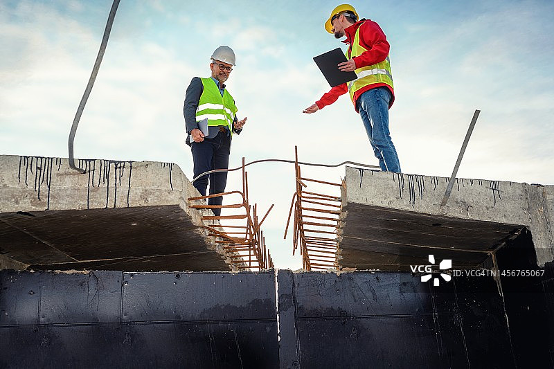 工程师与投资者在道路施工现场图片素材