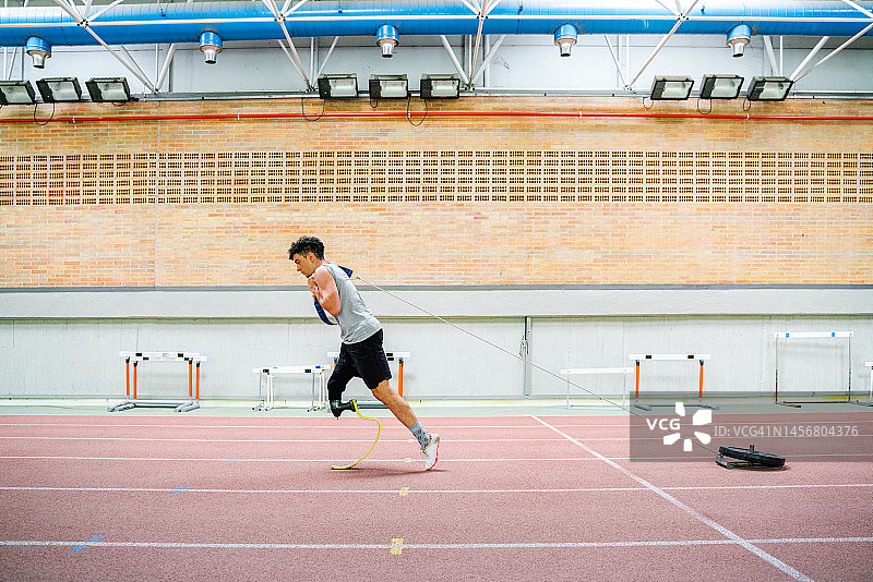 在田径跑道上进行负重训练的装有假肢的健壮白人男子图片素材