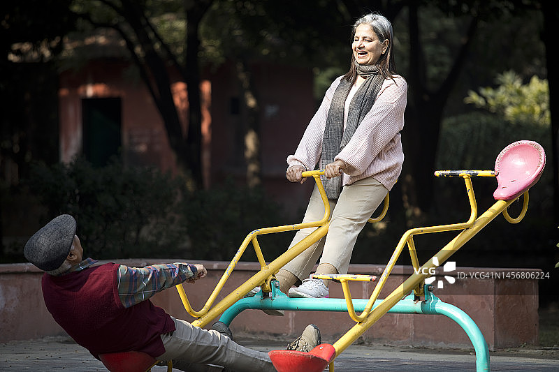 老年夫妇在公园玩跷跷板图片素材