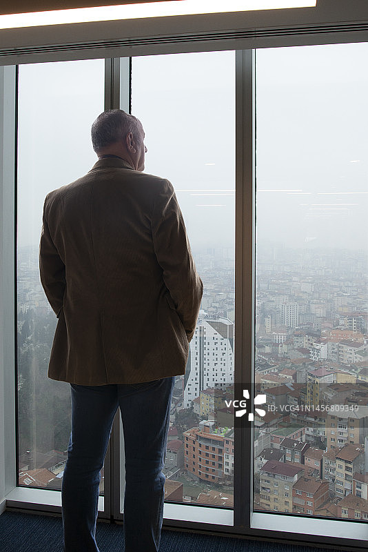 商务人士眺望办公室窗外图片素材