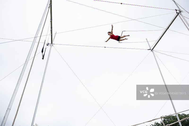 在空中飞翔的中年杂技演员图片素材