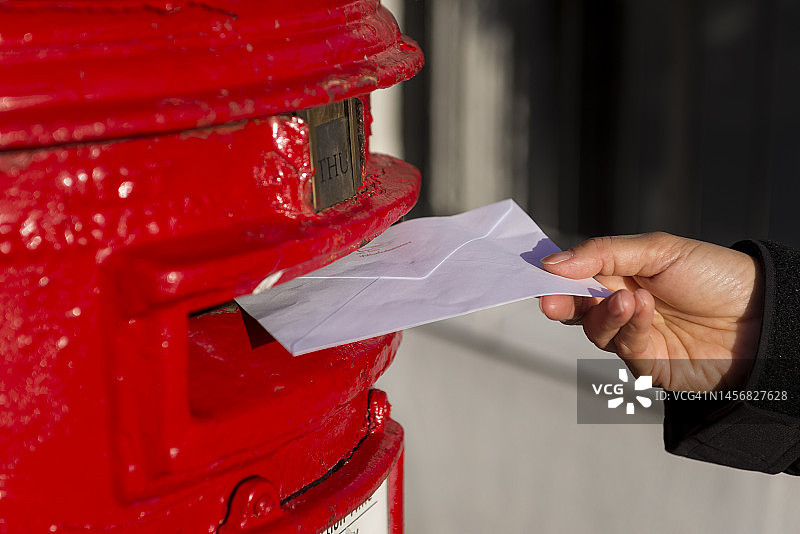 英国伦敦红色邮筒投递信件特写图片素材