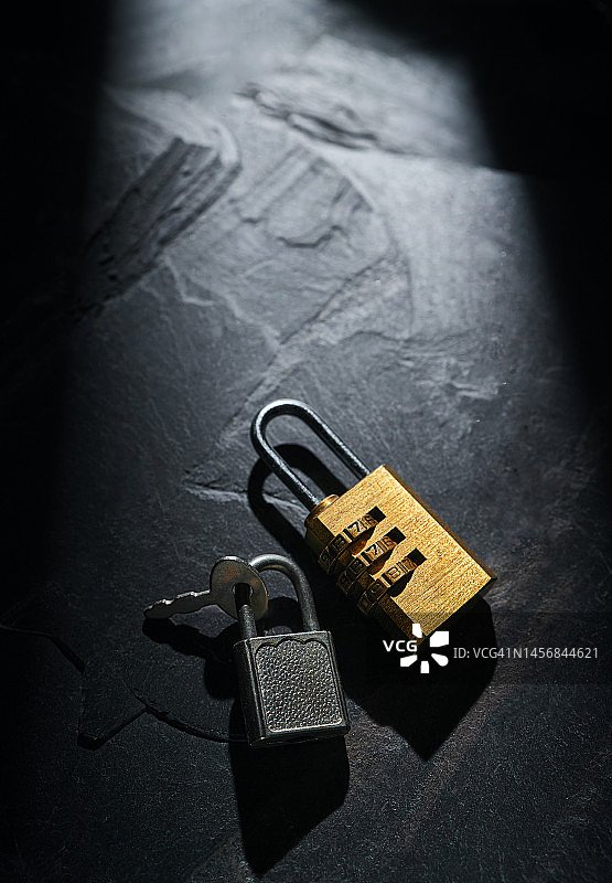 黑色岩石地面上的挂锁图片素材