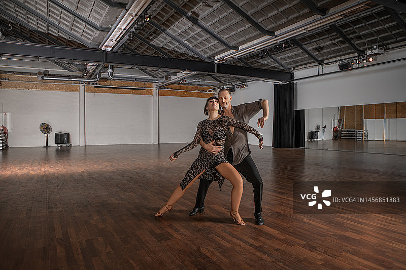 检查员注意事项：已提供财产放行单。学校在一栋废弃建筑内有3个不同的区域。美丽的夫妇在彩排区一起跳伦巴舞图片素材