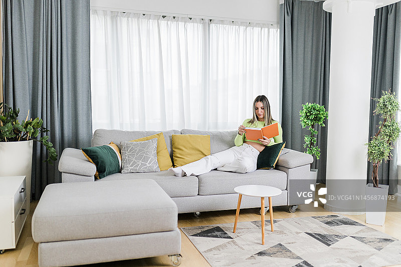 年轻女人在家中阅读和休息图片素材