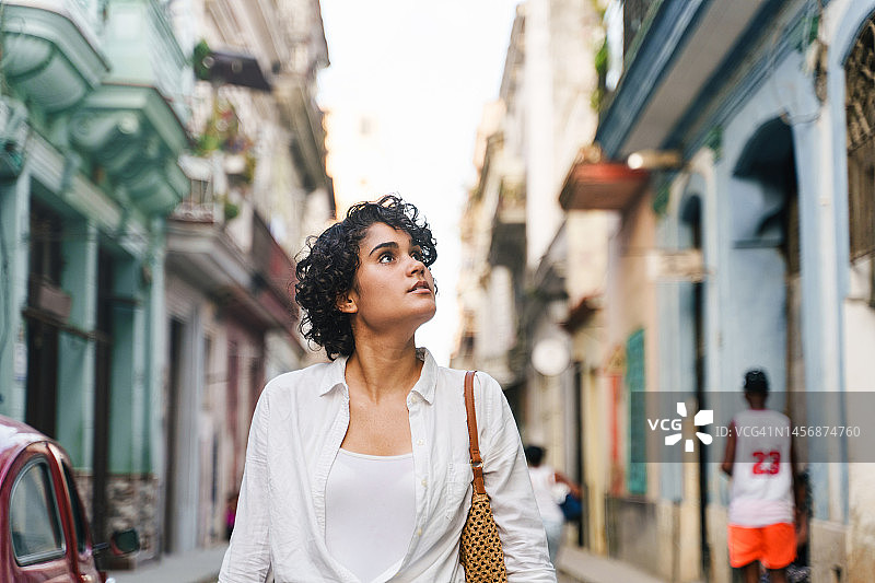 年轻的西班牙裔女人走在哈瓦那的街道上图片素材