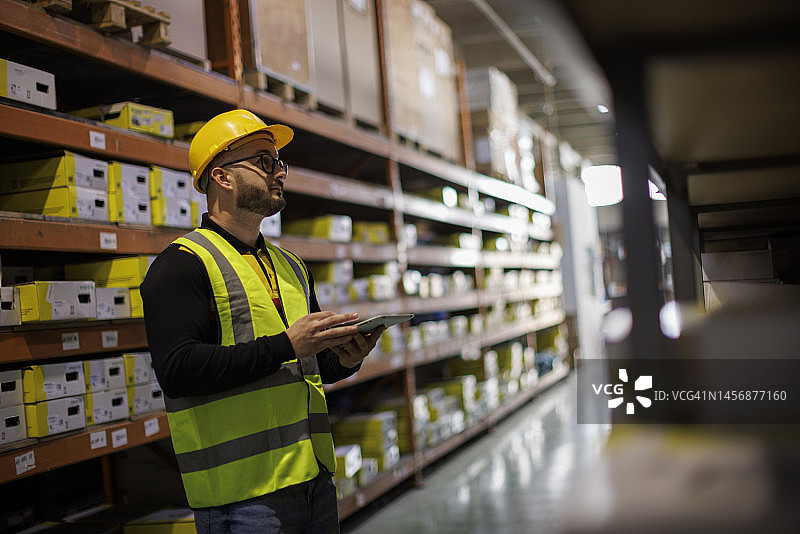 正在做检查清单的仓库男员工图片素材